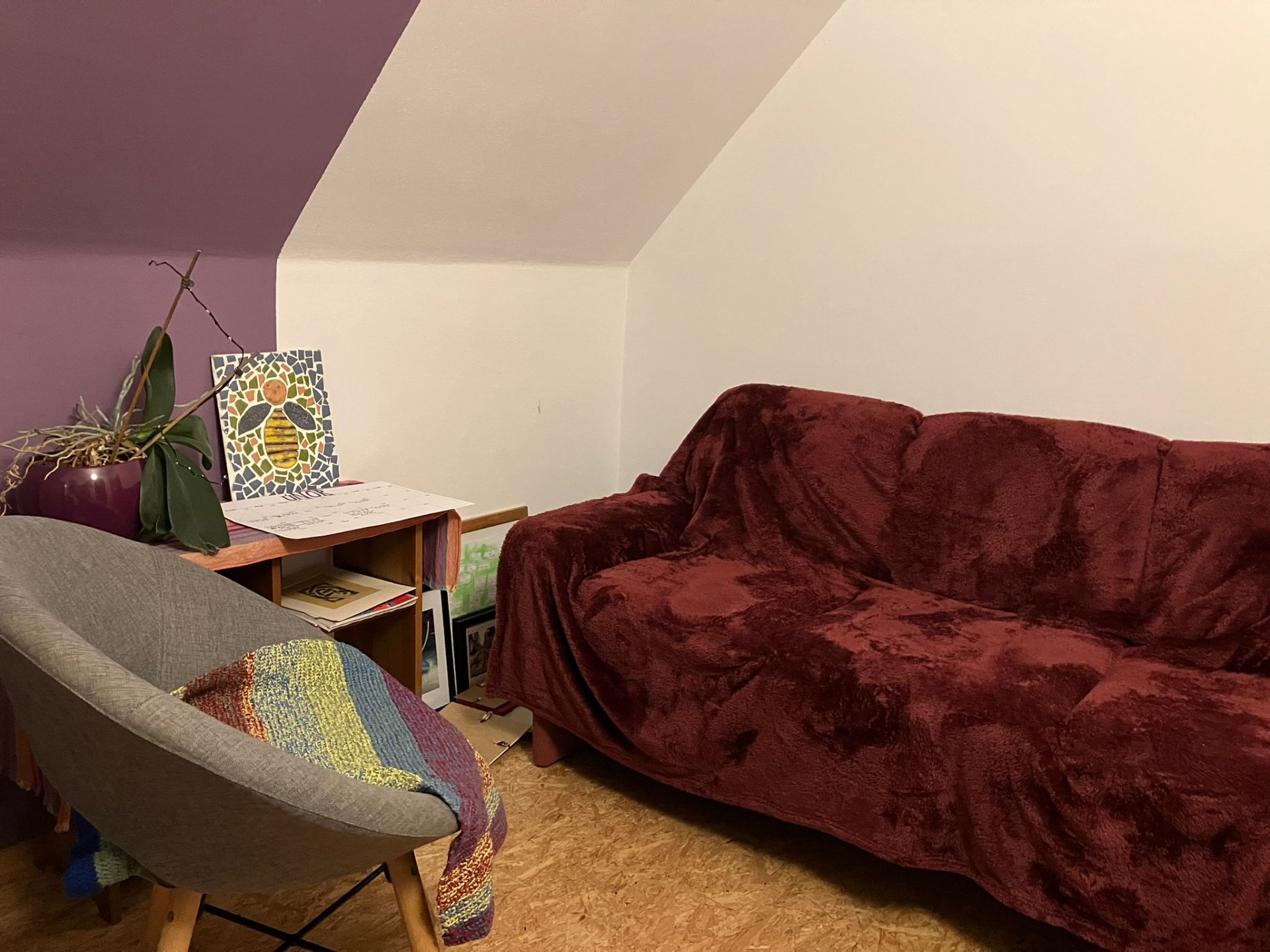 Tereza Tichá - místo setkávání, červená sedačka, křesílko, stolek s květinou a mozaikou.